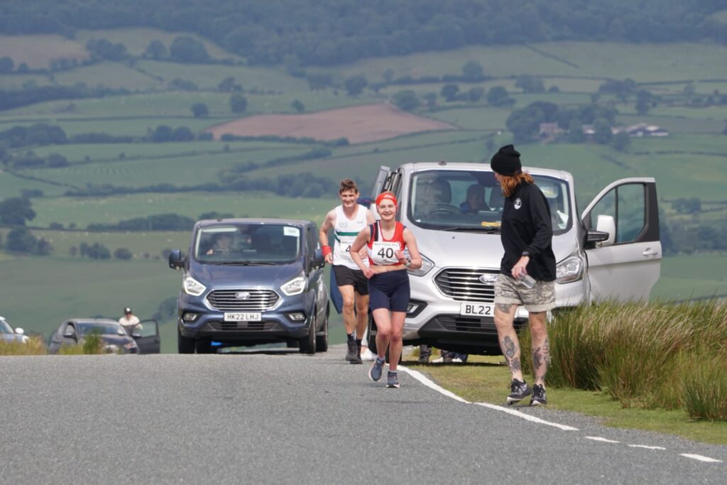 A stage in the Welsh hills, support vans in tow